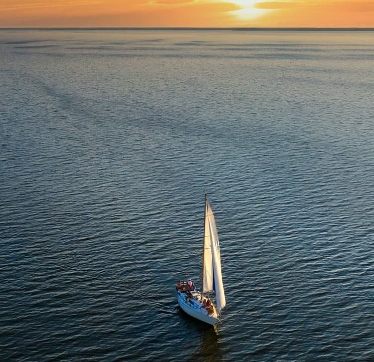 sailing yacht with sunset in the background