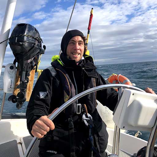 young man steering a yacht off shore