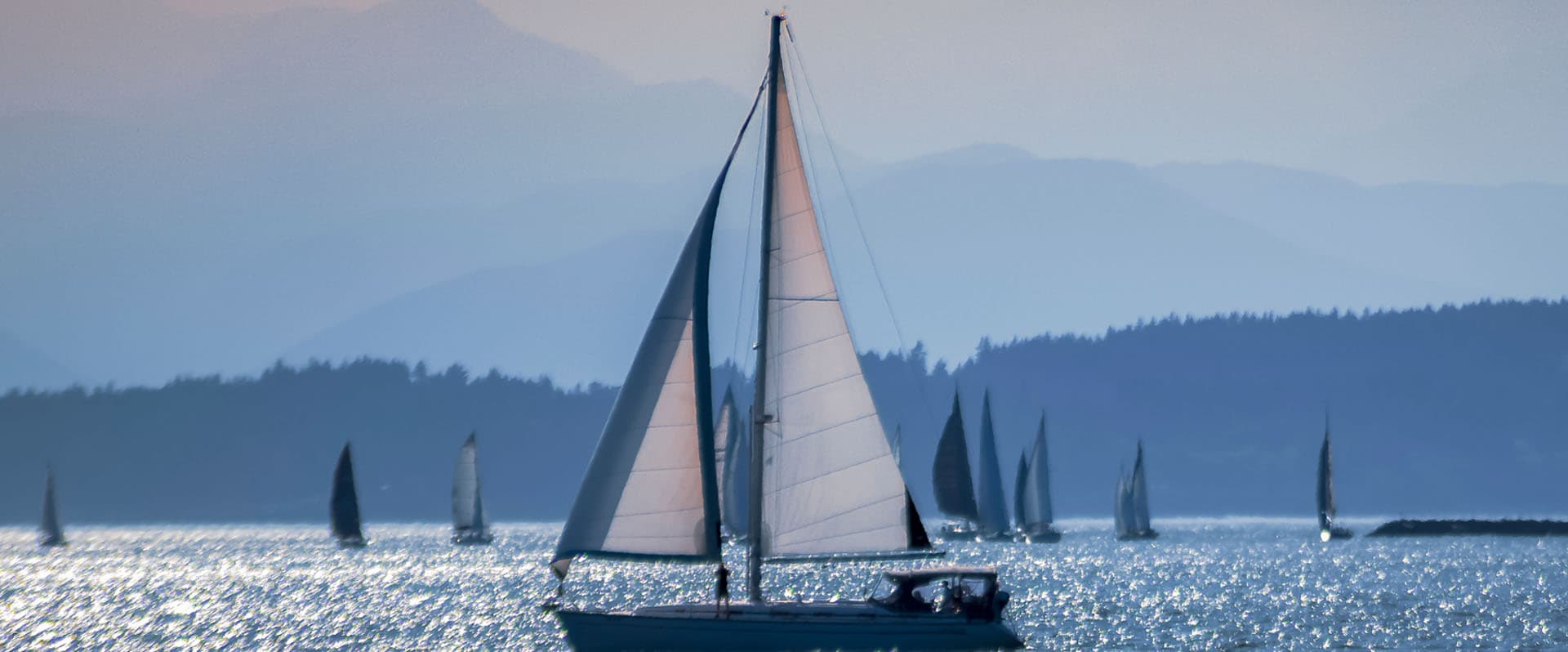 Sailing yacht sails in front of a mountain